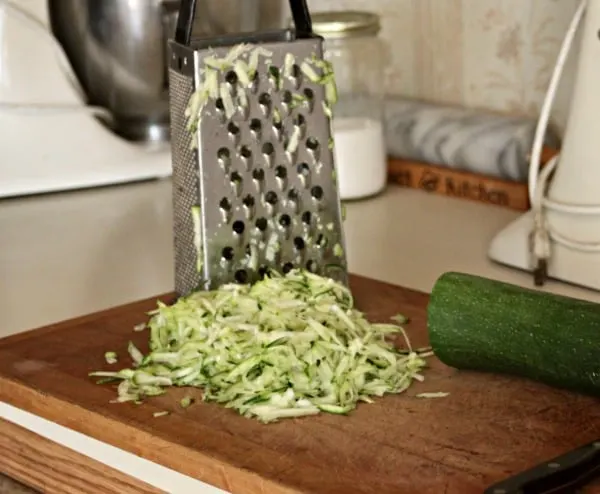Grating zucchini on a box grater.