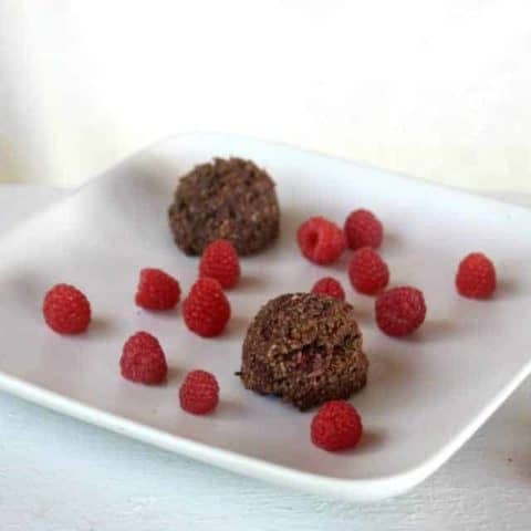 Chocolate Raspberry Coconut Macaroons on a plate with fresh raspberries