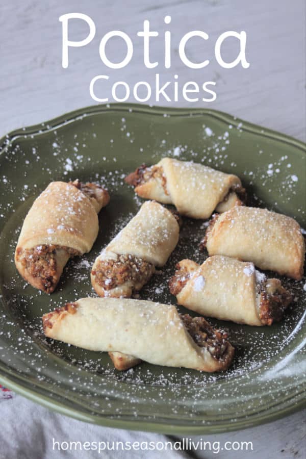 Potica Cookies on a green plate sprinkled with powder sugar.