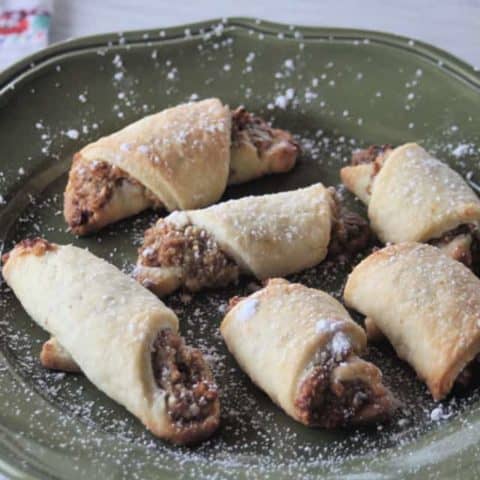 Potica cookies on a plate sprinkled with powdered sugar.