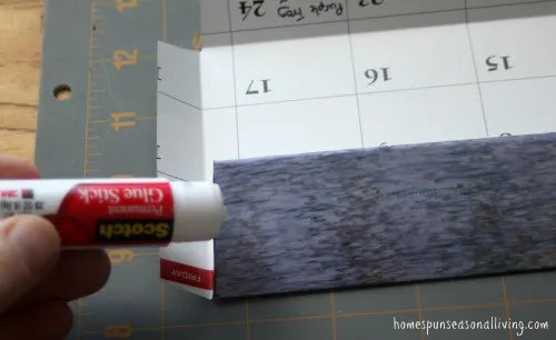 An envelope being folded and glued with a hand holding a glue stick.