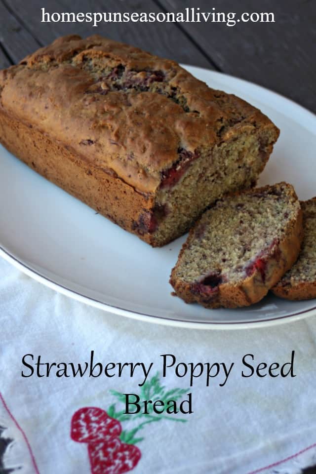 Sliced strawberry poppy seed bread on a platter with napkin.