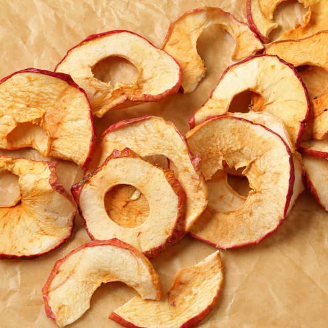 Dried apple slices on a board.