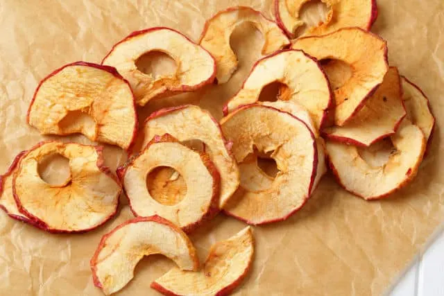 Dried apple slices on a board.
