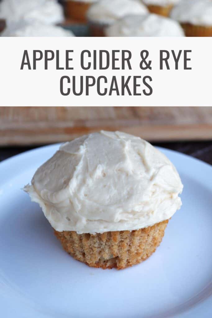 A frosted cupcake sits on a white plate. Text overlay reads: Apple Cider & Rye Cupcakes.