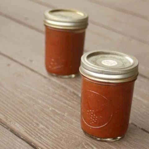 2 jars of roasted tomato pizza sauce on a table.