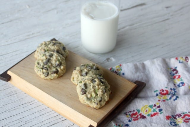 Zucchini Oat Chocolate Chip Cookies on a wooden platter with a glass of milk.