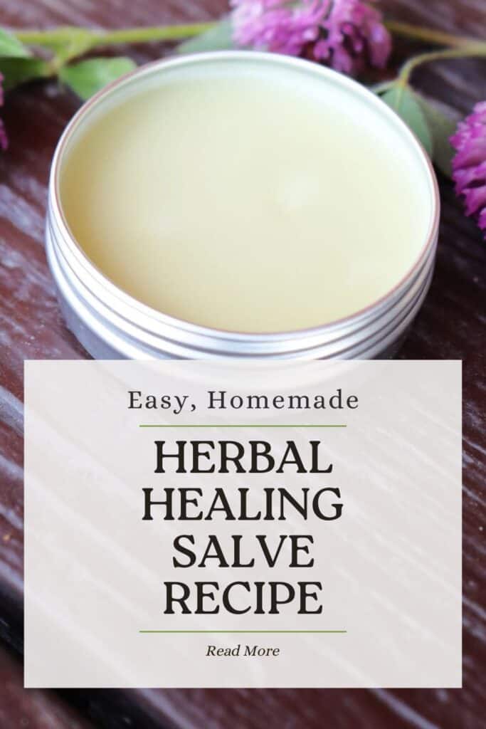 A open metal tin showing a pale salve inside sits on a table. Text overlay reads: Easy, Homemade Herbal Healing Salve Recipe.