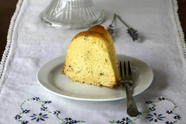 Slice of lavender bundt cake on a plate with a fork.
