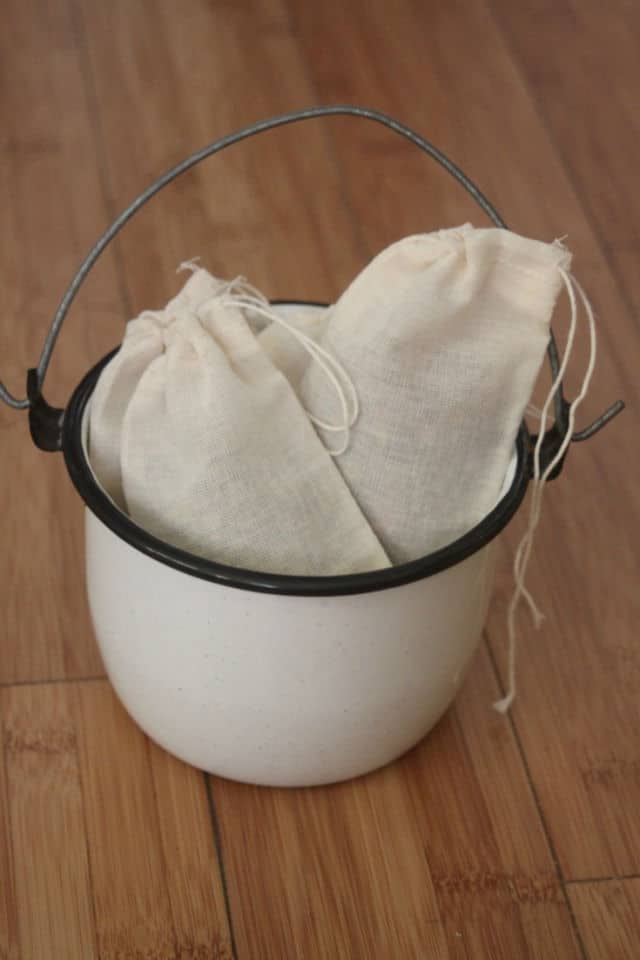 Bags of herbal bath teas in a metal bucket.