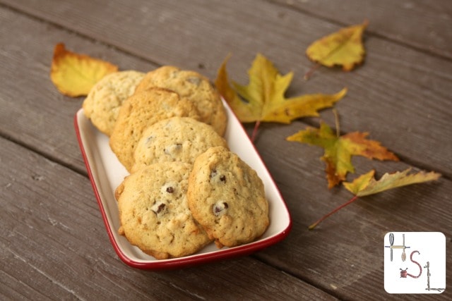 Granola cookies on a plate with fall leaves on the table next to it.