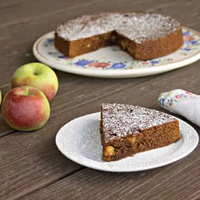 A slice of apple molasses cake on a plate.