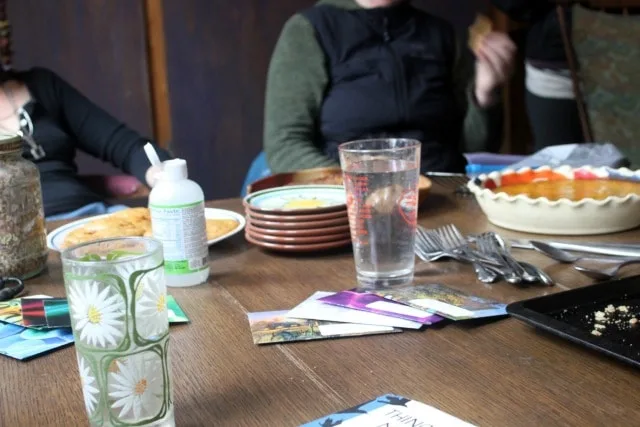 A table with water glasses, envelopes, and people talking.