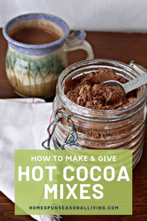 Homemade hot cocoa recipe in a jar with measuring spoon inside it, sitting in front of a mug of hot cocoa with text overlay.