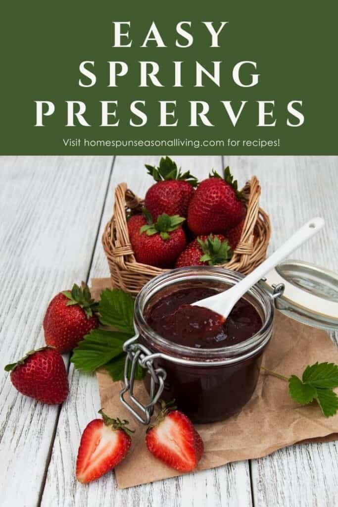 An open jar of strawberry jam with a spoon sticking out of it surrounded by fresh strawberries with text overlay reading: easy spring preserves.