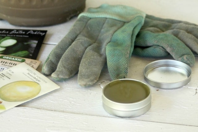 Tin of gardener's salve with gloves and seeds