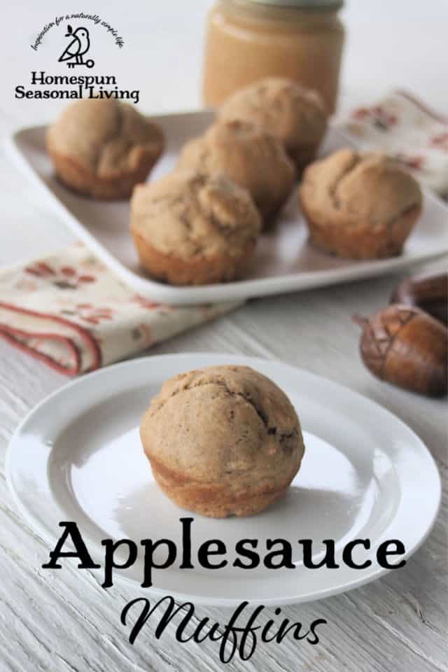 Applesauce muffin on a plate in the foreground with more muffins on a plate behind it. 