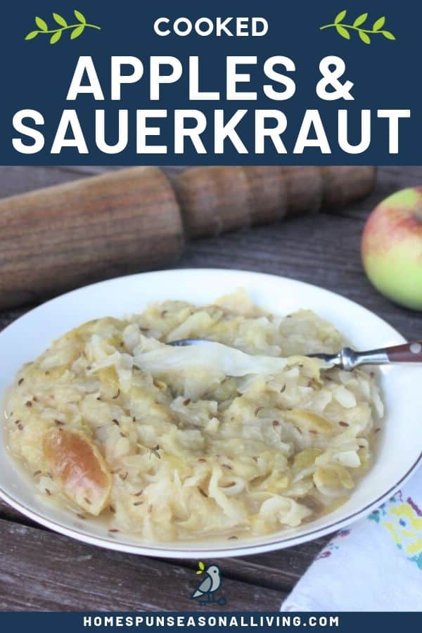 Cooked apple sauerkraut side dish in a bowl with a spoon sitting next to a napkin with a sauerkraut pounder and apple behind it includes text overlay.