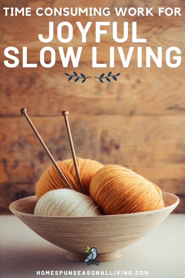 A bowl of yarn with knitting needles sticking out of it with text overlay stating: time consuming work for joyful slow living.