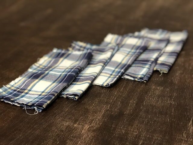Flannel hankies in a diagonal line on a wooden table. 