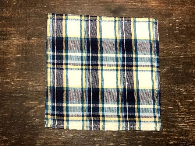 A square of flannel with a zigzag stitch sewn around the edges.