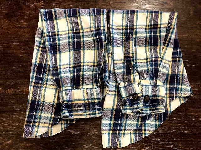 Sleeves cut off upcycled flannel shirts sitting on a table.