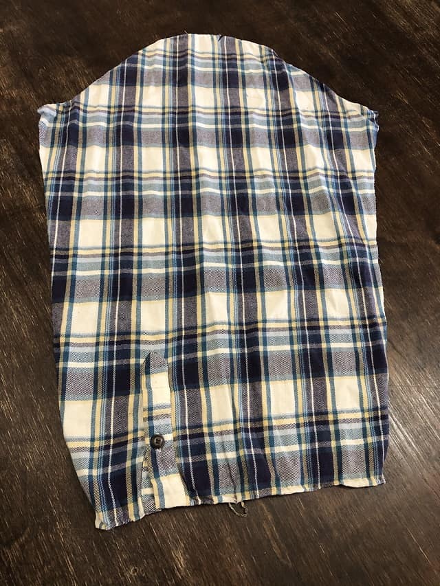 The opened sleeve of a flannel shirt laying flat on a table.