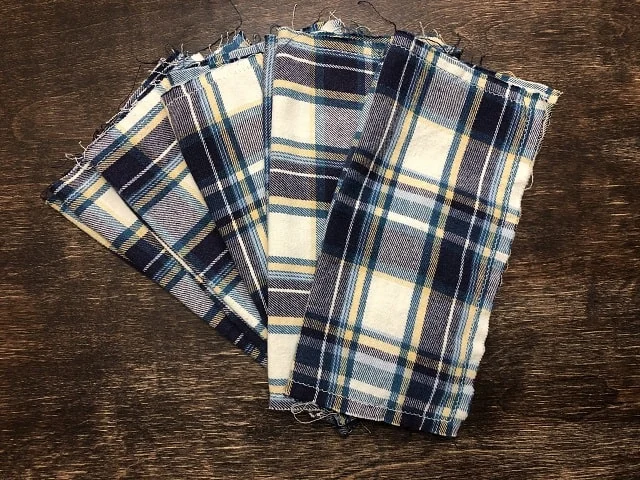 A stack of flannel hankies spread out into a fan pattern on a table.
