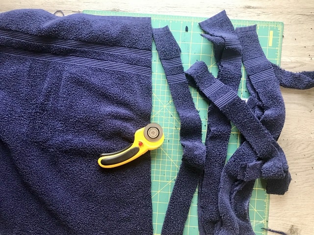 Towel being cut into strips with a rotary cutter