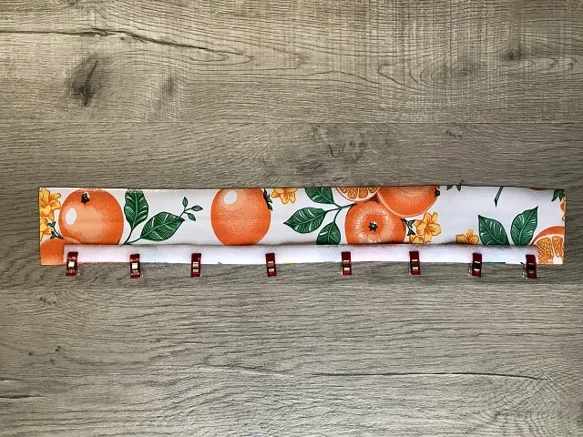 Hook and loop clipped to long edge of oilcloth rectangle