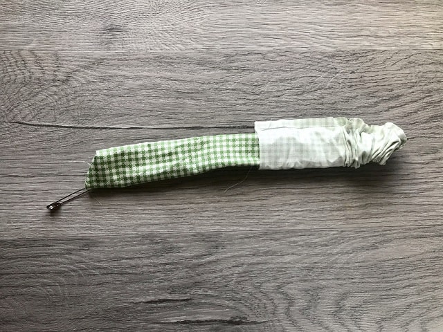 Tube of fabric being pushed through itself to turn right side out