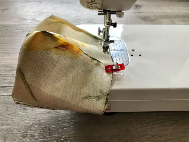 Sewing machine stitching around top of basket