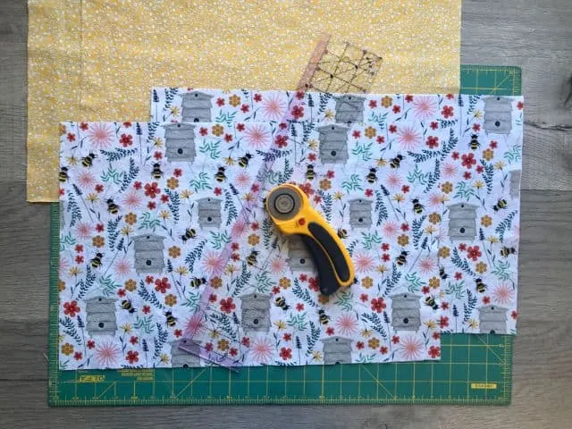 Two fabrics cut to size with rotary cutter and acrylic ruler