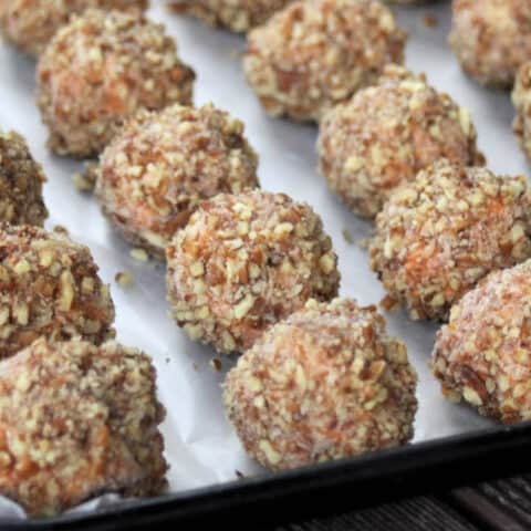 Nut crusted sweet potato balls on a cookie sheet.