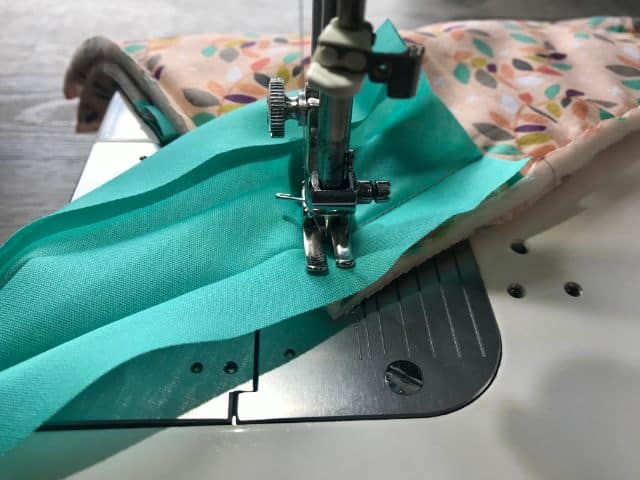 Sewing machine sewing bias tape to the corner