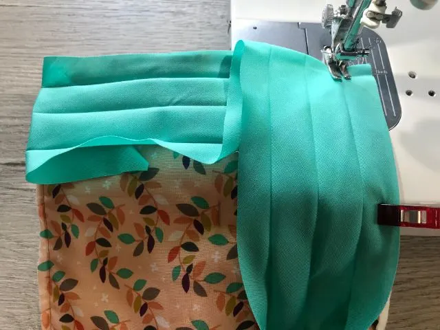 Sewing machine sewing bias tape to back of hot pad