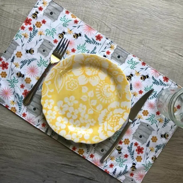 A placemat sitting with a plate, knife, and fork on top of it.