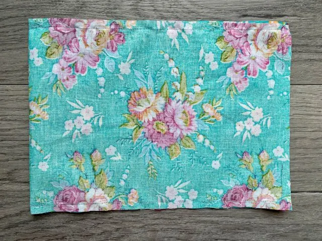 Inside out rectangle of teal floral fabric sewn with 3" opening at one end