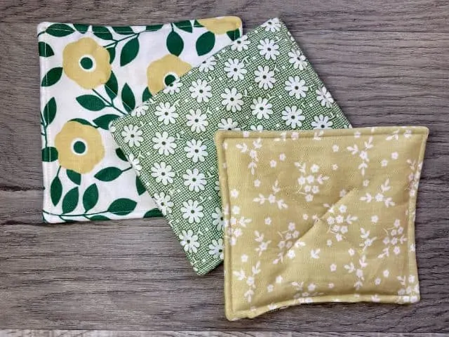 Three fabric mug rugs in white and green floral fabric
