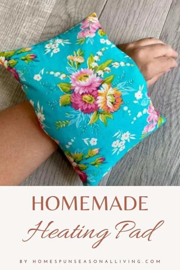 A blue floral heating pad sitting on a woman's wrist with text overlay stating: Homemade Heating Pad.