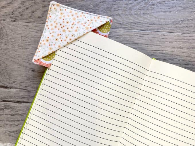 Floral fabric corner bookmark being inserted on corner of book pages