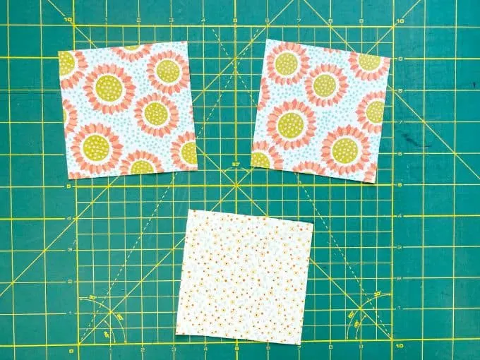 4 x 4 fabric squares with flowers on green cutting mat