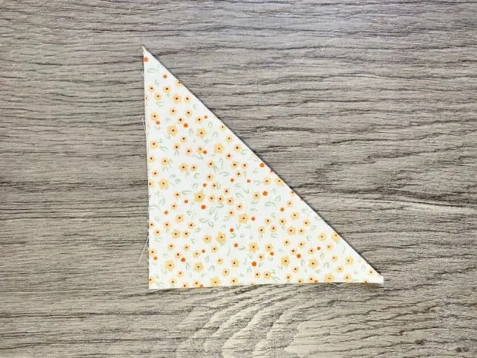 Square of fabric folded in half to make a triangle