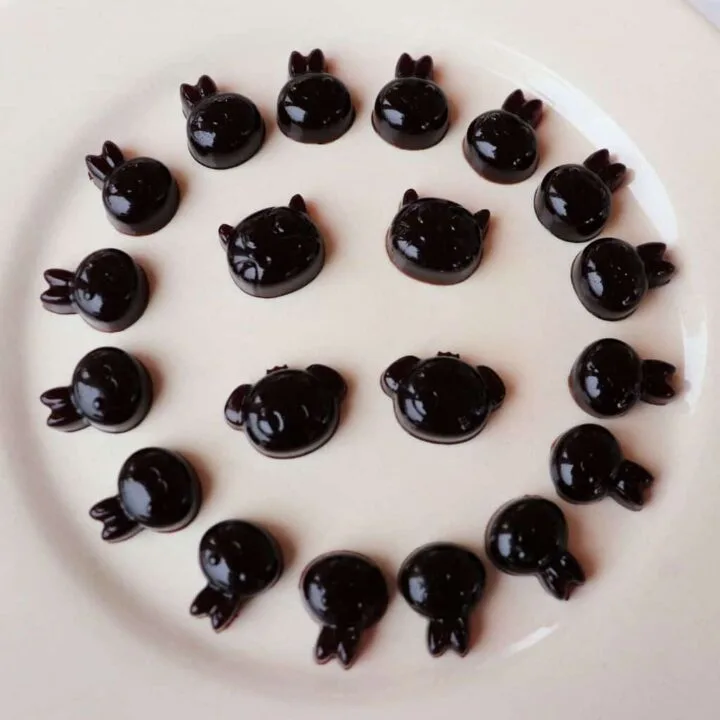 A white plate with elderberry syrup gummies in animal shapes around the edge and in the center of the plate.