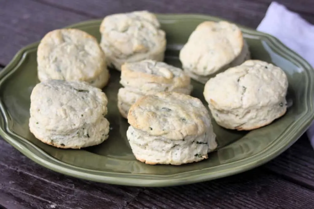 Chive biscuits spread onto a green platter.