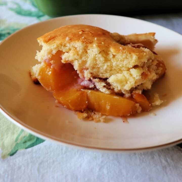 A piece of nectarine cobbler in a bowl ready to eat.