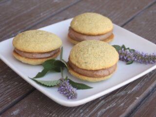 Anise hyssop whoppie pies on a white plate with fresh hyssop flowers.