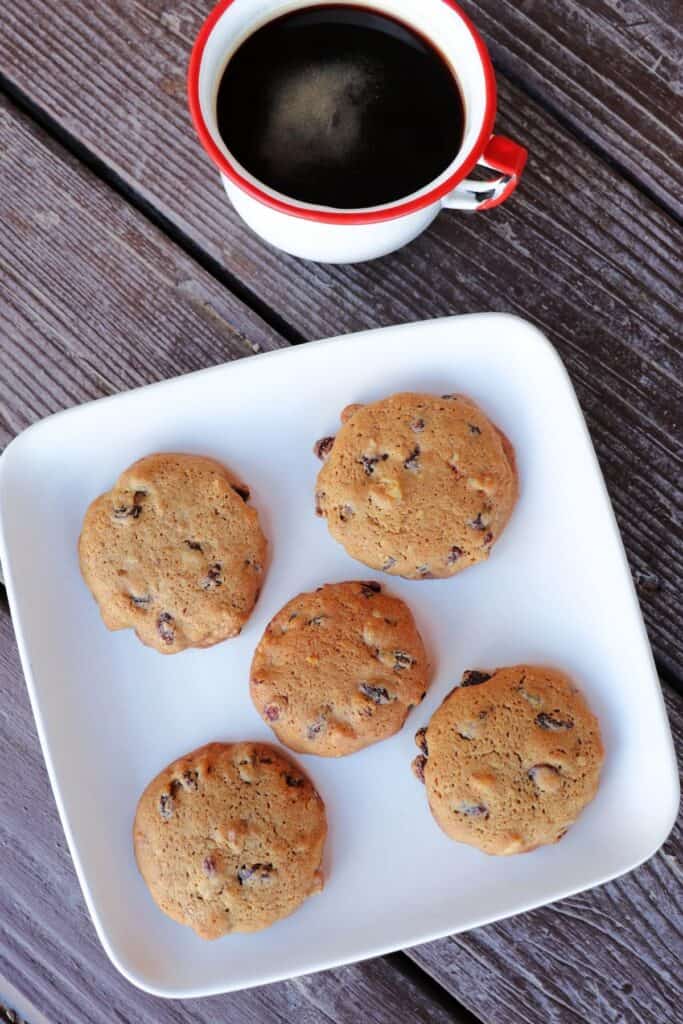 5 hermit cookies on a square plate with a coffee as seen from above. 