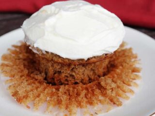A frosted applesauce cupcake on a plate.