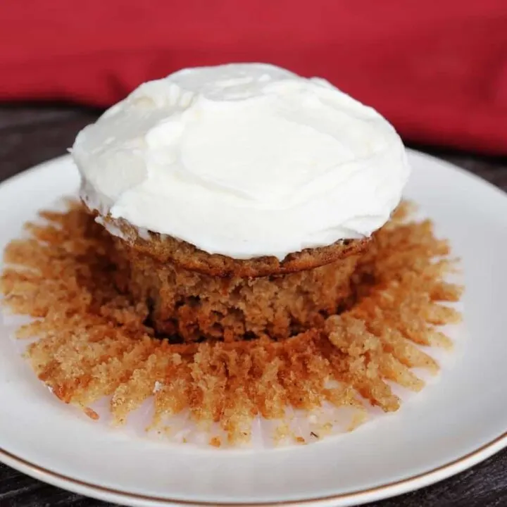 A frosted applesauce cupcake on a plate.